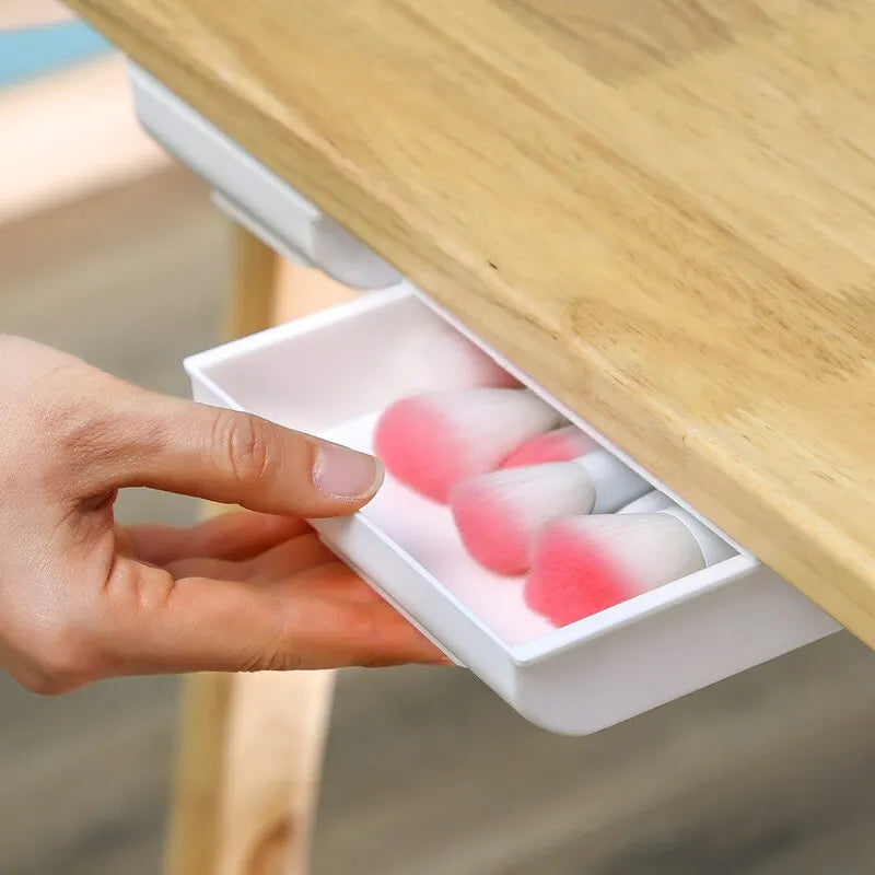 1 white self-adhesive storage box, a tray for makeup pencils and more, which tucks away under the desk
