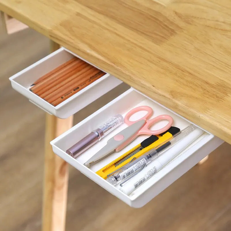 1 white self-adhesive storage box, a tray for makeup pencils and more, which tucks away under the desk
